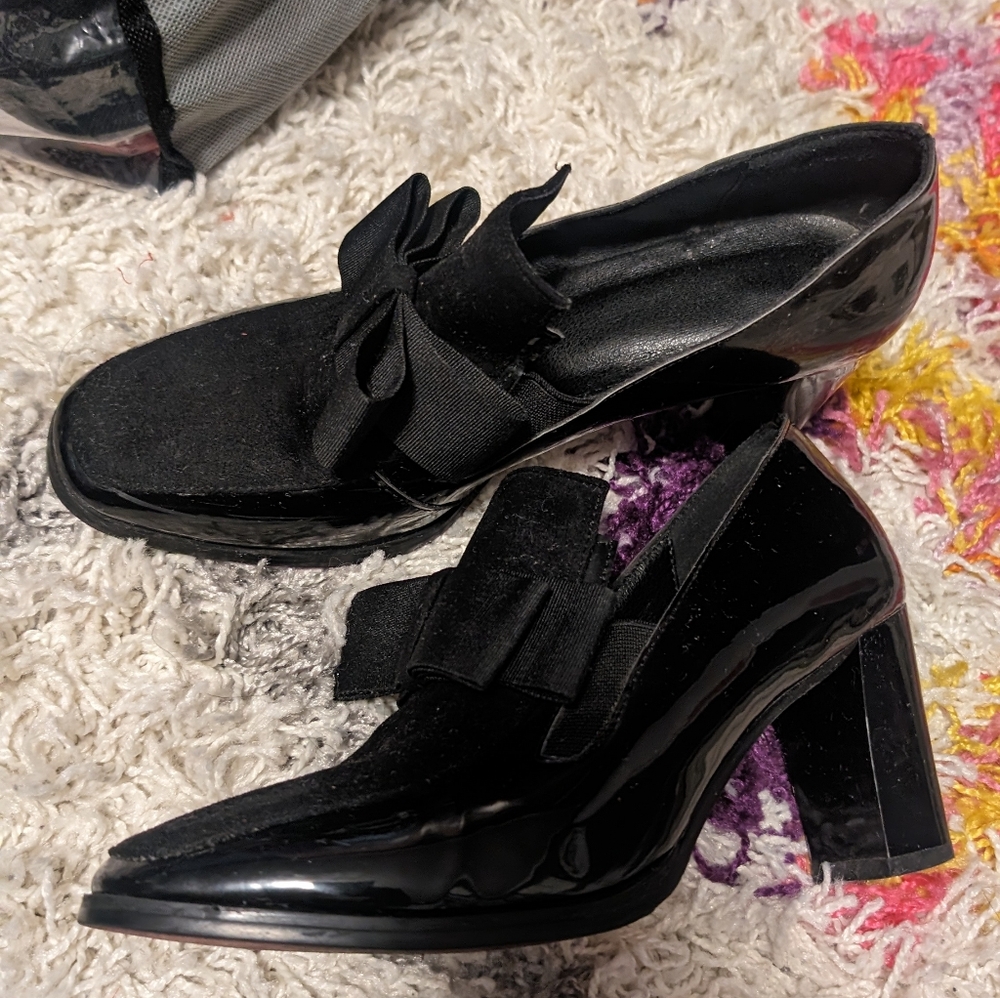 Unmarked Suede and patent leather bow pumps have red bottoms on them. Used